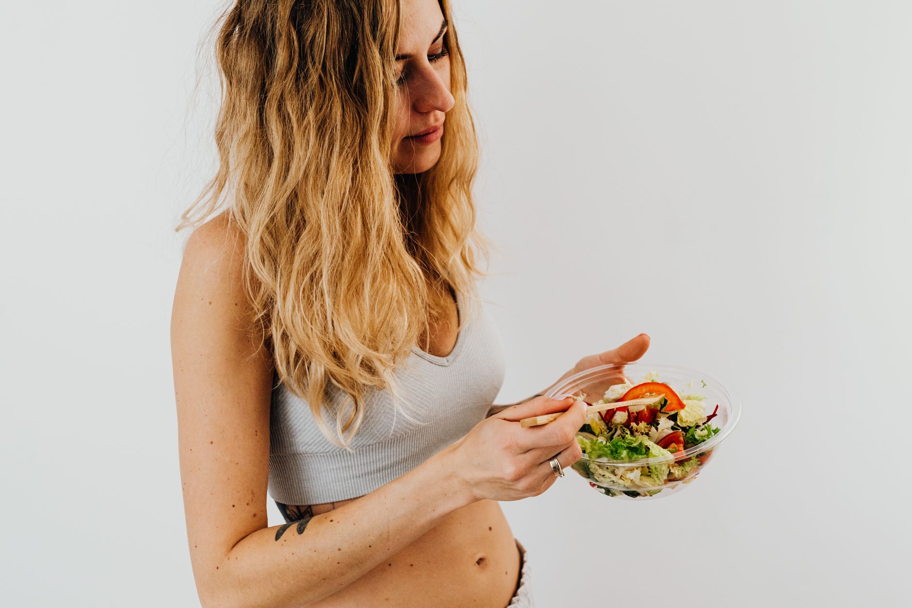 Mujer sonriente con bowl de alimentos frescos y nutritivos para el equilibrio hormonal