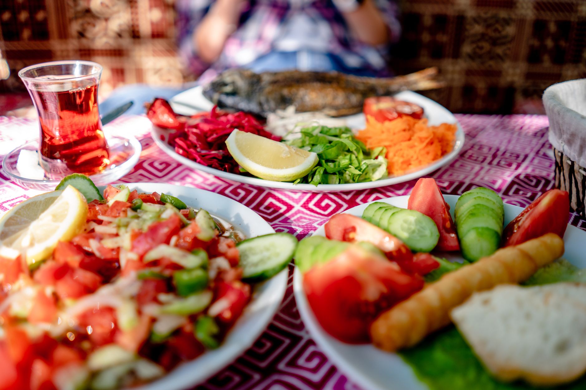 Mujer madura con alimentos mediterráneos frescos como verduras, aceite de oliva y frutos secos sobre mesa