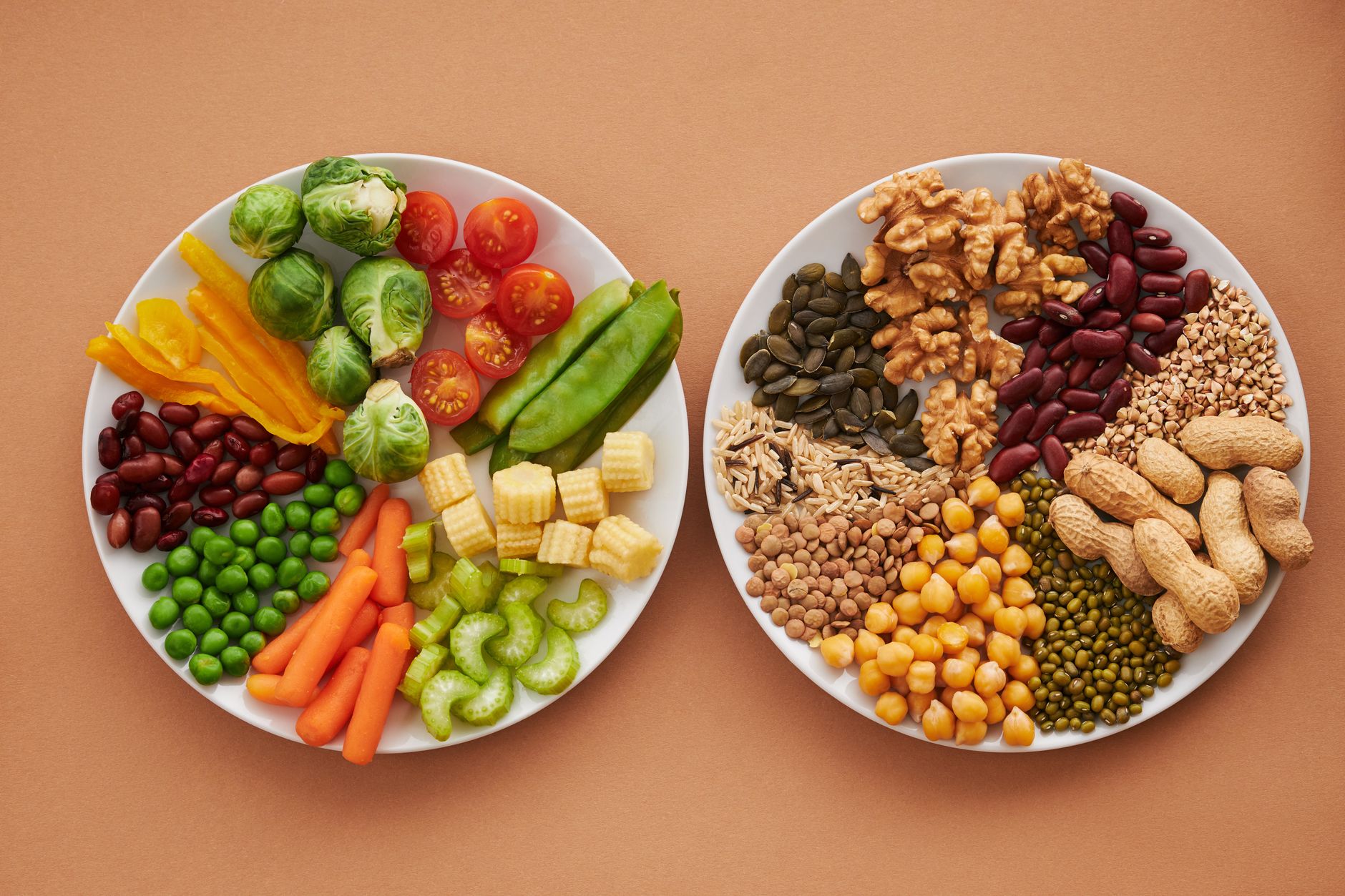 Tazones coloridos con lentejas, garbanzos, verduras asadas y aguacate sobre mesa de madera, alimentación vegetariana adolescente