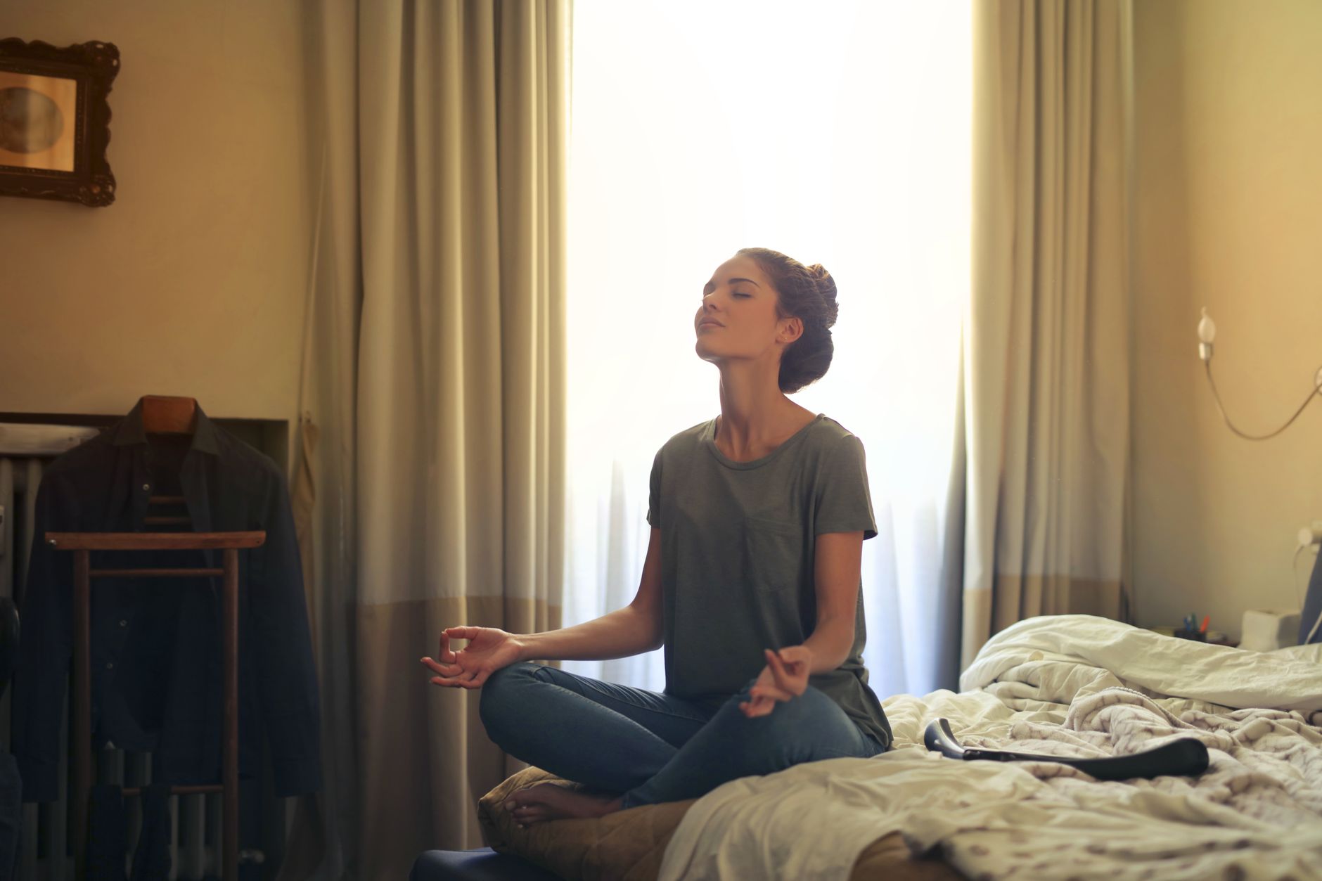 Mujer sentada en calma practicando respiración consciente en un espacio interior iluminado naturalmente