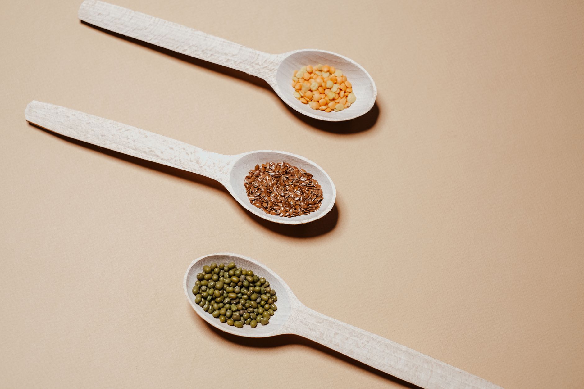 Tazones con soja, semillas de lino, lentejas y garbanzos sobre mesa de madera, fuentes de fitoestrógenos