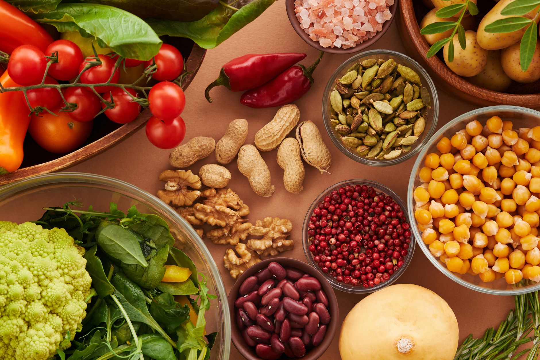 Variedad colorida de ingredientes saludables: verduras, nueces, semillas y especias vistas desde arriba.