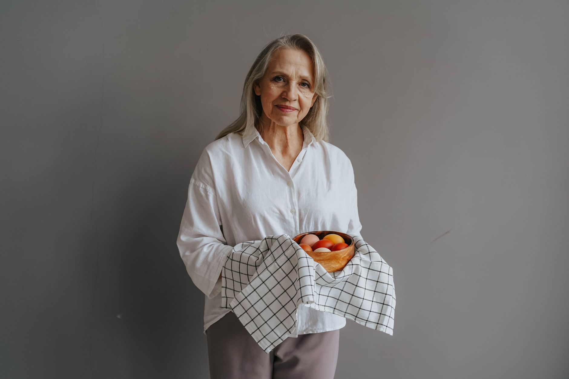Mujer madura sonriente disfrutando una comida saludable y equilibrada en su cocina