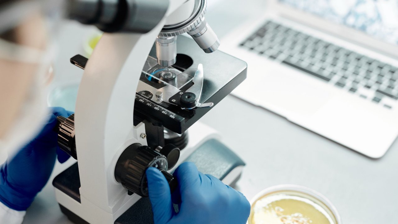 Microscopio y laptop en un laboratorio de investigación científica