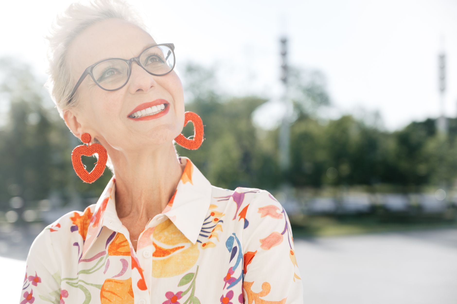 Mujer madura sonriente sosteniendo su pecho con gesto de bienestar y salud cardiovascular