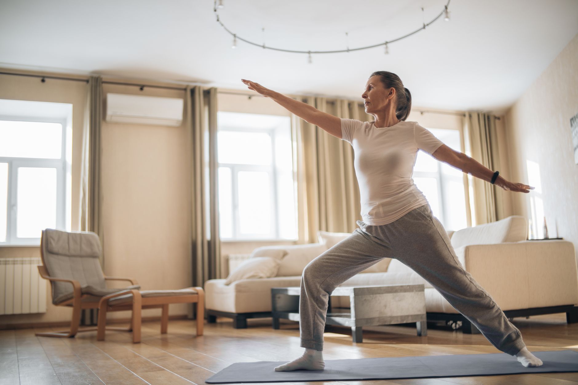 Mujer madura practicando yoga al aire libre, promoviendo salud ósea y bienestar en la posmenopausia