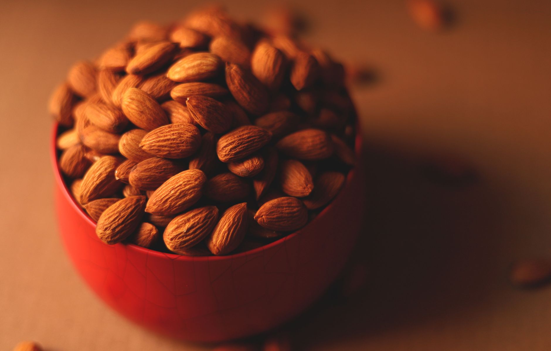 Almendras en un tazón rojo, ideales para un snack saludable.